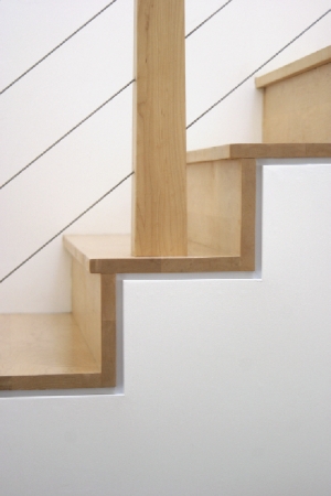 Steps of natural maple lead to the family’s bedrooms upstairs.